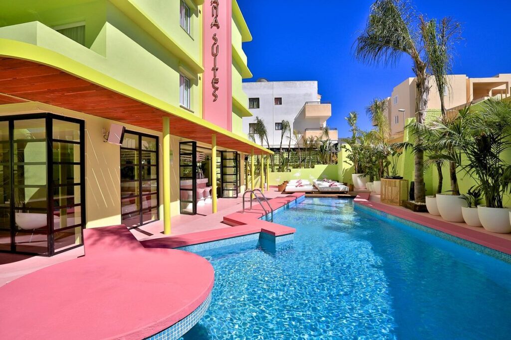 Loungen aan het zwembad van het kleurrijke Tropicana Ibiza boutique hotel in Playa d'en Bossa, geïnspireerd door de film cocktail van Tom Cruise en de jaren '80. 