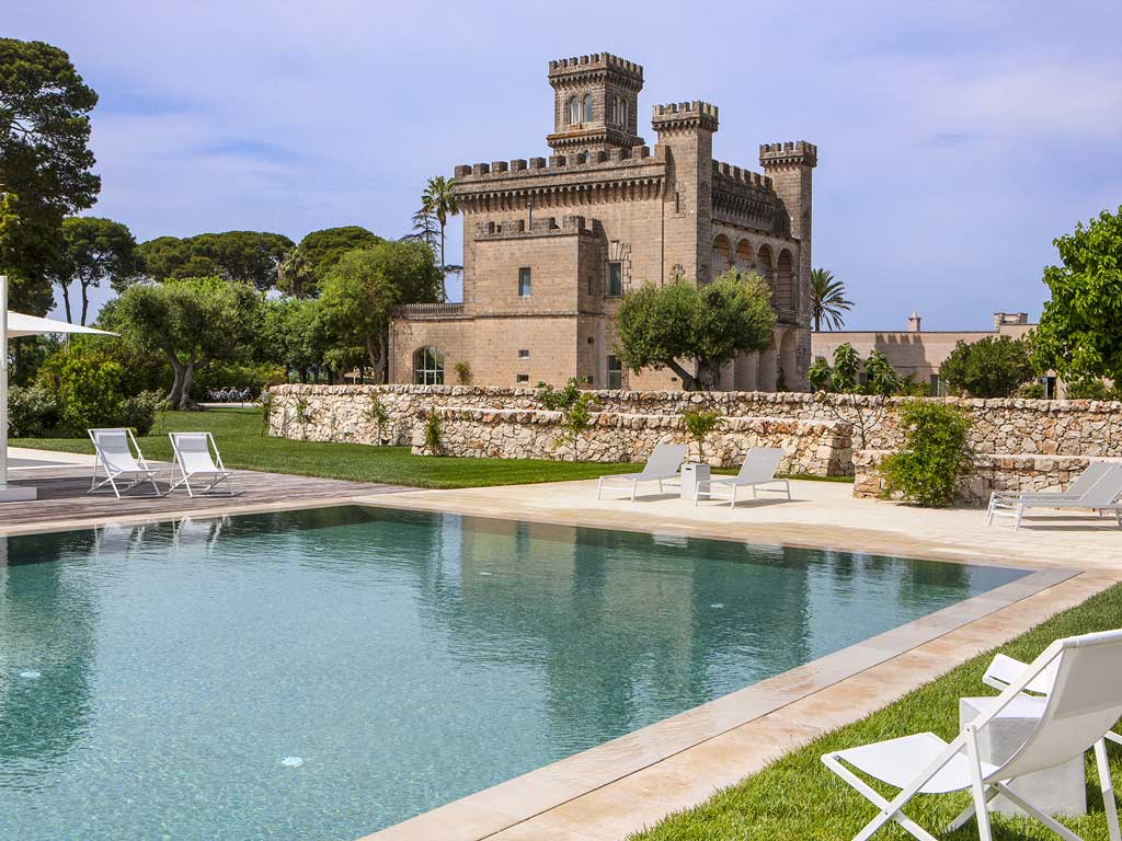 Genieten aan het zwembad met uitzicht op het prachtige 10e-eeuws kasteel van het kleinschalige boutique resort Vinilia Wine Resort in Manduria in Puglia
