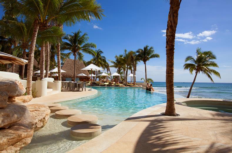 Het stijlvolle zwembad bij het kleinschalige hotel Mahekal Beach Resort in Yucatan Mexico vanaf waar je uitkijkt over zee