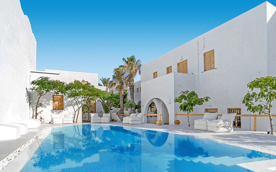 Loungen aan het stijlvolle zwembad van het kleinschalige appartementencomplex Santorini Crystal Blue Suites in Kamari