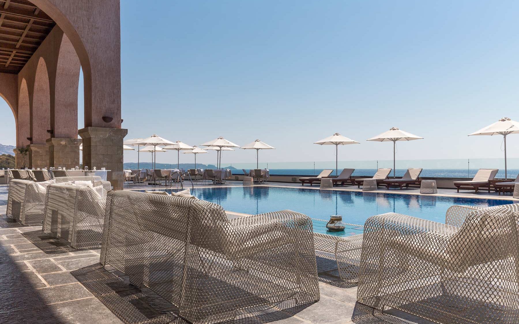 Ligbedden en stoelen aan het zwembad van het kleinschalige boutique 5 hotel & spa in kiotari op Rhodos