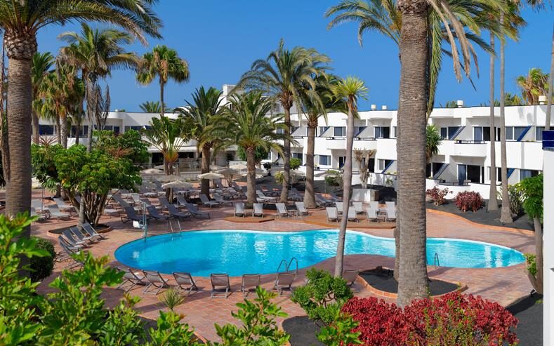 Uitrusten op een ligbedje aan het heerlijke zwembad van het kleinschalige hotel H10 Ocean Dunas op Fuerteventura
