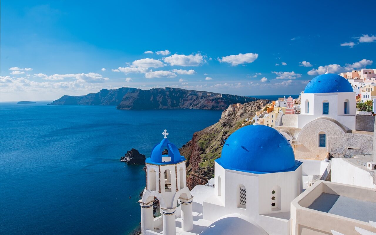 Uitzicht op Griekse kerkjes met blauwe daken op het eiland Santorini en veel kleinschalige hotels in Europa