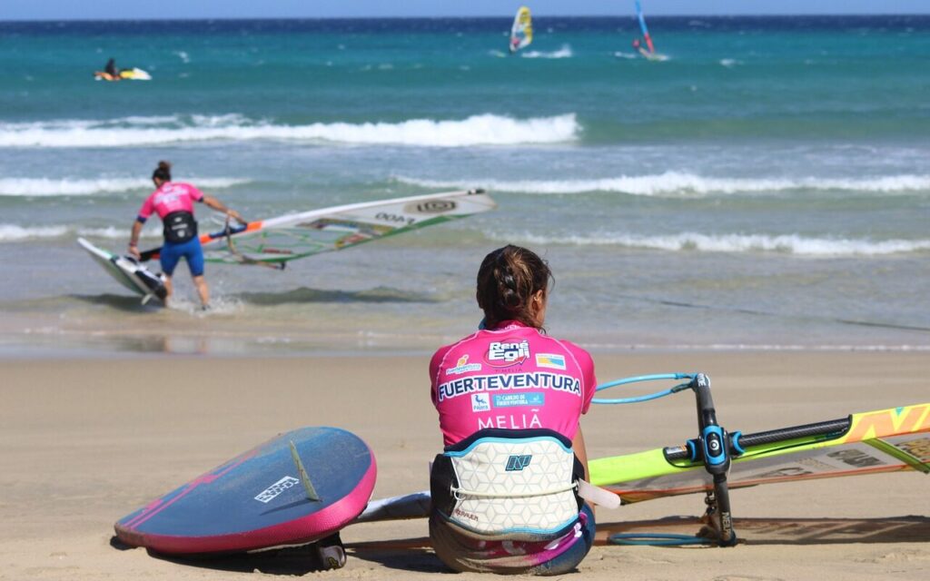 Meisje aan het wachten om te leren surfen op een van de beste surf spots op Fuerteventura