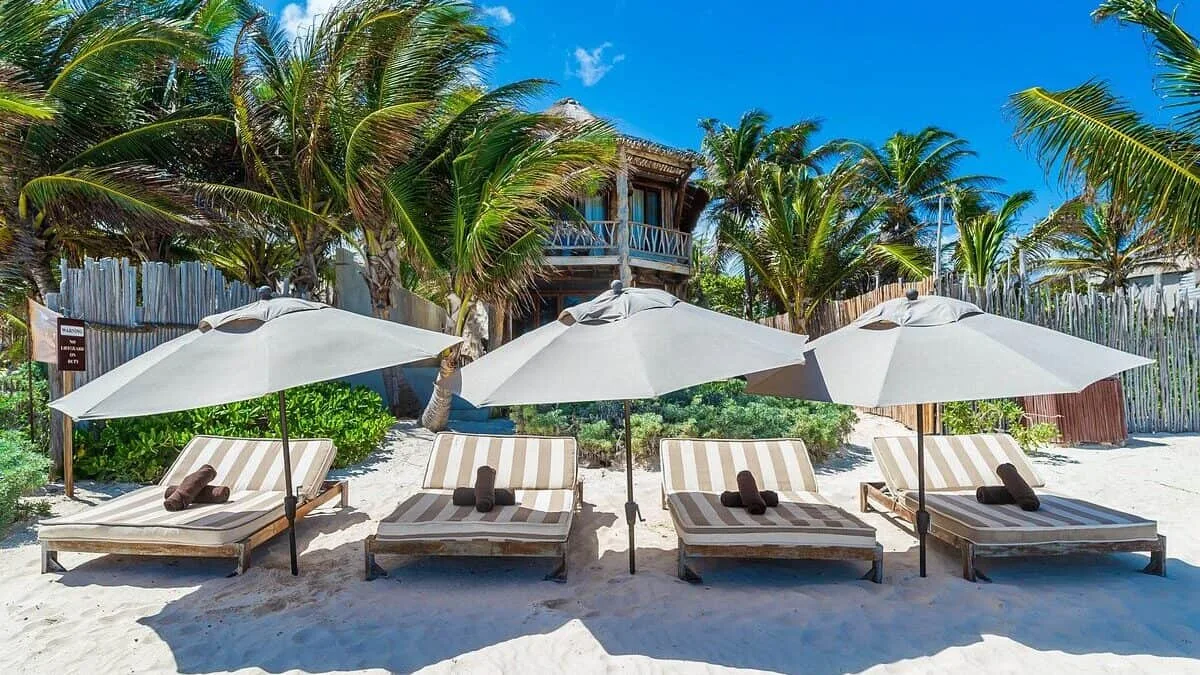 Uitrusten op een ligbedje aan het strand bij het kleinschalige hotel Casa Ganesh in Tulum, Yucatan in Mexico