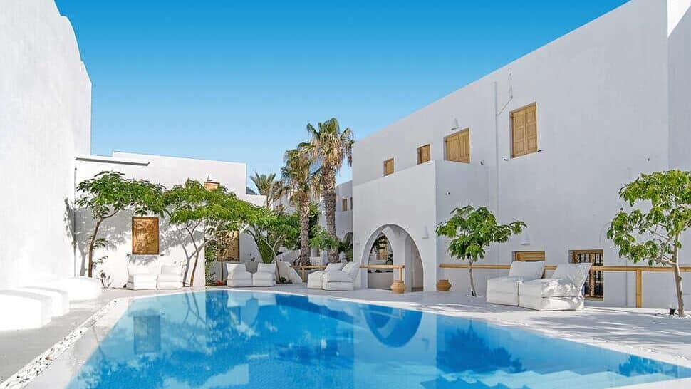 Loungen aan het stijlvolle zwembad van het kleinschalige appartementencomplex Santorini Crystal Blue Suites in Kamari